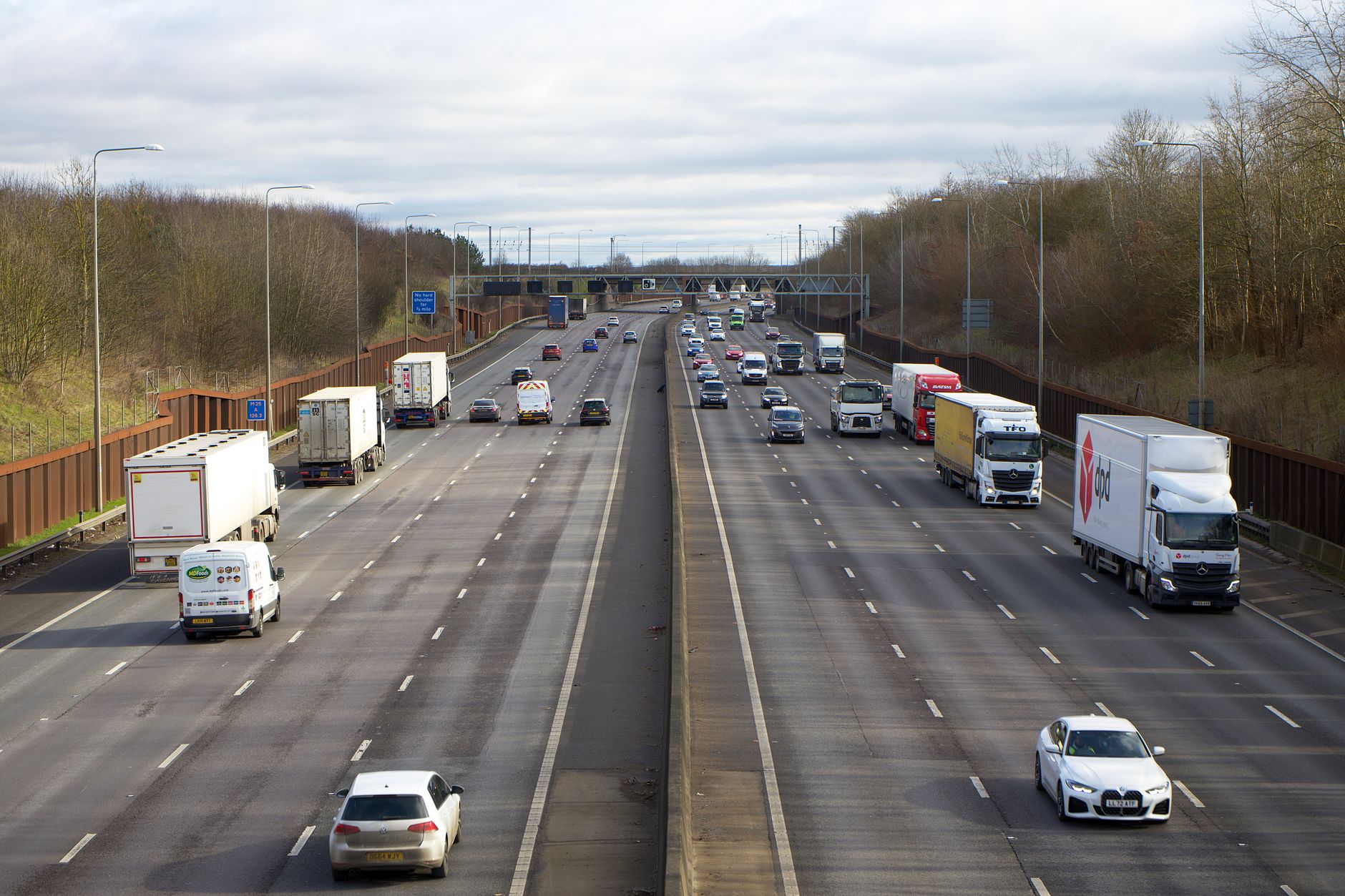 Vehicles and freight trucks travelling along a multi-lane motorway.